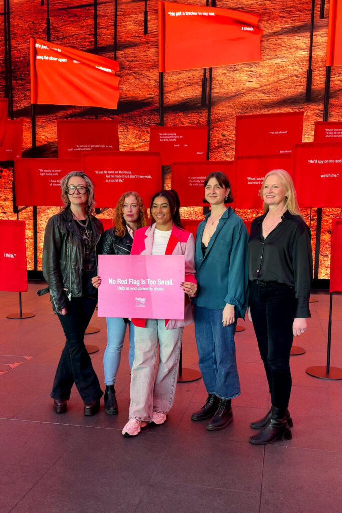 From left to right, Lorien Haynes, Victoria Yeates, Chanita Stephenson, Caitlin O'Ryan and Hetti Bankworth-Nanton stood holding the "No Red Flag Is Too Small. Help us end domestic abuse" sign