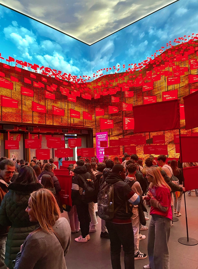 The Outernet filled with red flags on the screens and physically, with lots of people among them