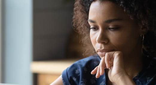 Brunette woman looking at a laptop.