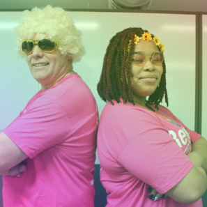A woman and a man stood back to back wearing 1970s fancy dress